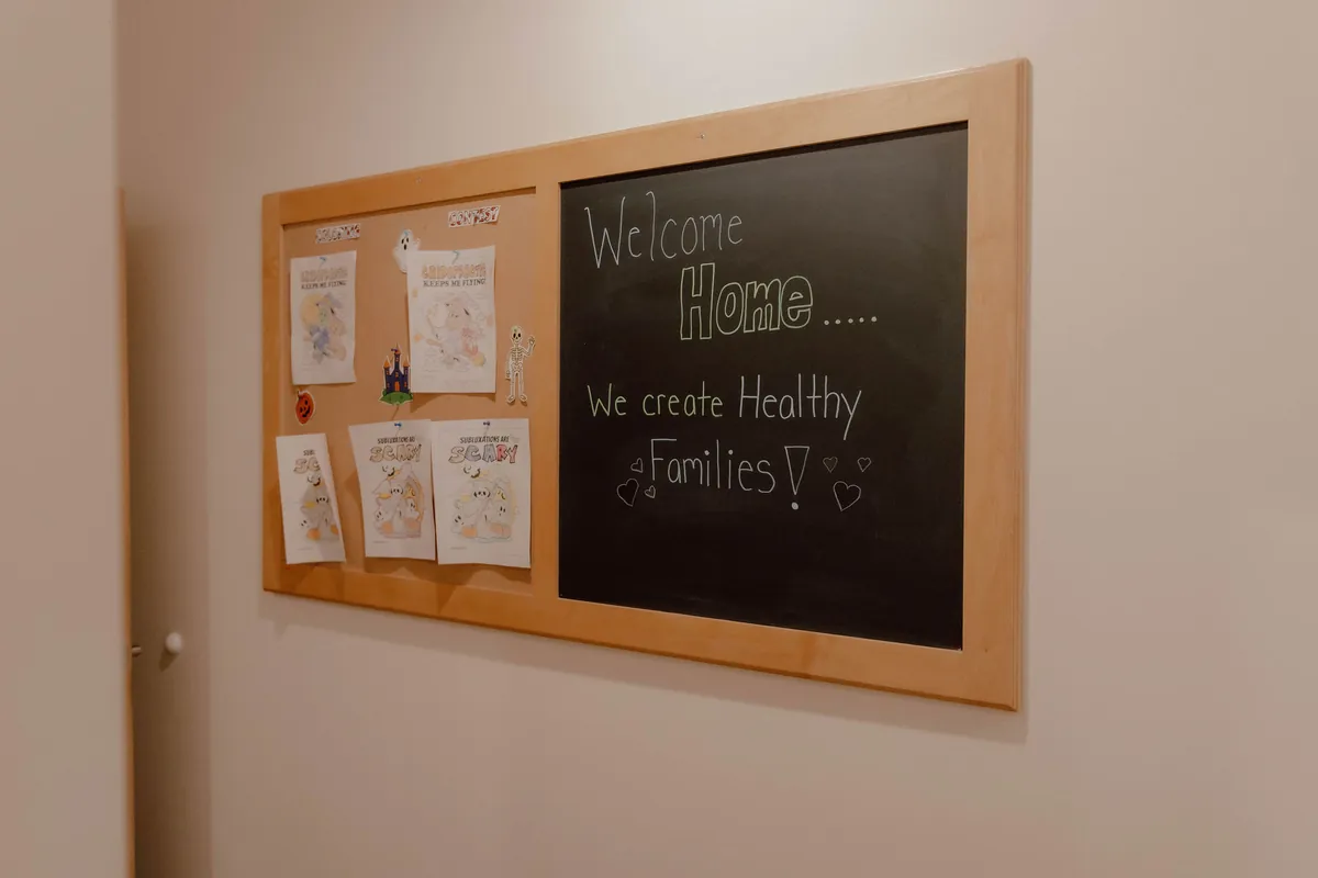 A chalkboard in the clinic that reads "Welcome Home… We create Healthy Families"
