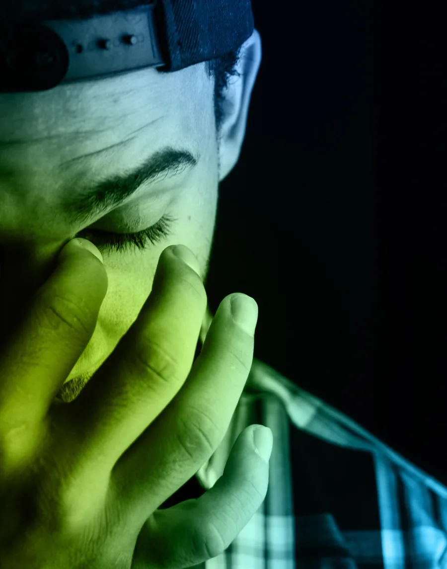 A person holding the side of their head in pain from a headache