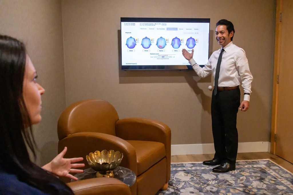 Adrian, our neurofeedback technician, walking a patient through their brain map on screen